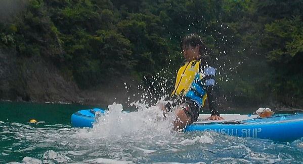 ボードに座りながら水中で激しくバタ足をするトレーニング