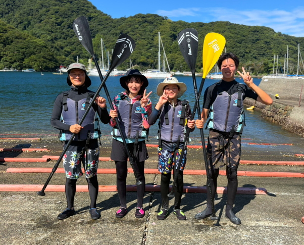 東風が吹く西伊豆・安良里でSUPを楽しむ家族連れ