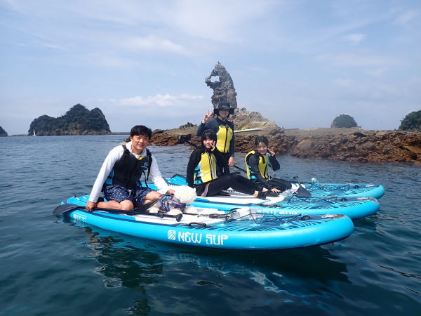 大迫力の大田子海岸ゴジラ岩をバックにSUPの上で記念撮影