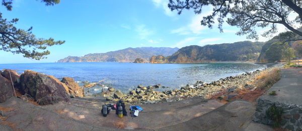 西伊豆・黄金崎ビーチのダイビングエントリー口から望む穏やかな海と景勝地「黄金崎」の全景